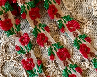 May include: Beige trim with red and green embroidered flowers. The trim has a raised texture and is perfect for adding a touch of vintage charm to any project.