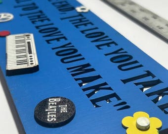 Teksty piosenek Beatlesów ozdobione i ożywione w trójwymiarowej sztuce ściennej.