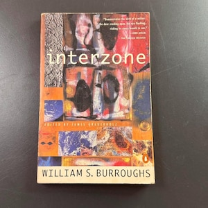 May include: A paperback book titled "Interzone" by William S. Burroughs. The cover features abstract art in orange, blue, and brown tones. The book is edited by James Grauerholz and published by Penguin.