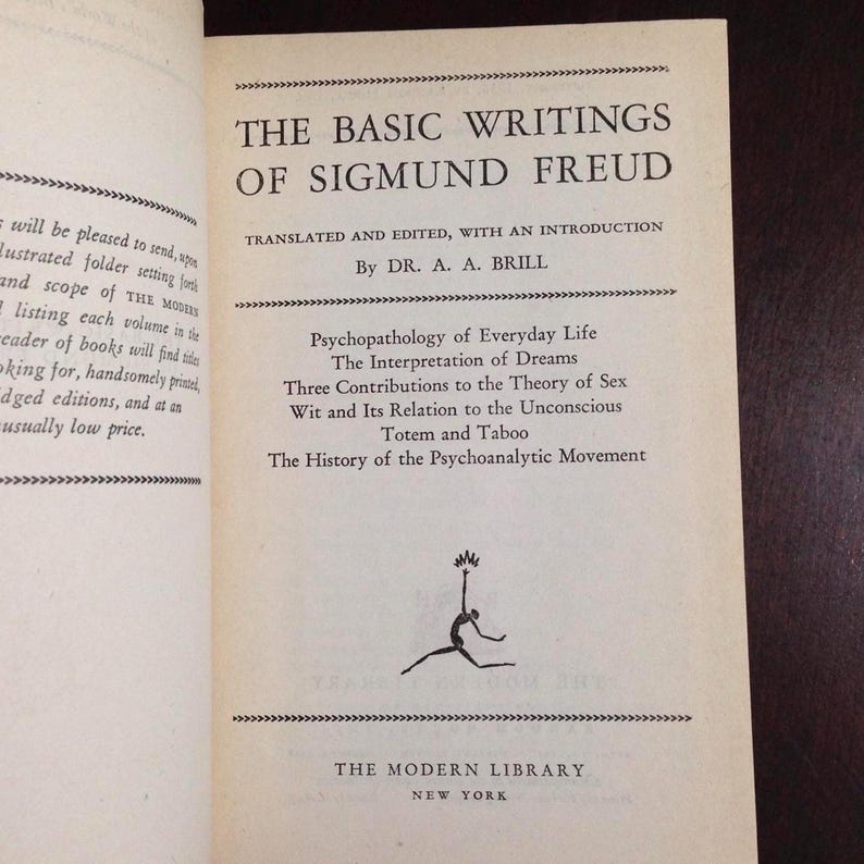 May include: A book cover with the title "The Basic Writings of Sigmund Freud" by Dr. A. A. Brill. The book cover is white with black text and a black border. The book cover also includes a list of the book's contents: Psychopathology of Everyday Life, The Interpretation of Dreams, Three Contributions to the Theory of Sex, Wit and Its Relation to the Unconscious, Totem and Taboo, and The History of the Psychoanalytic Movement.