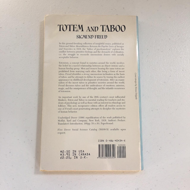 May include: A vintage paperback book cover with a white background and black text. The title is "Totem and Taboo" by Sigmund Freud. The book cover includes a description of the book and its contents, as well as pricing information.