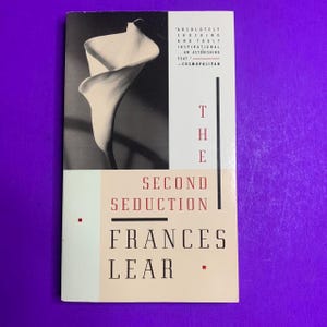 May include: A book cover with a black and white image of a calla lily. The title "THE SECOND SEDUCTION" is in red and black text, with the author's name, "FRANCES LEAR," below. A quote from Cosmopolitan is at the top.