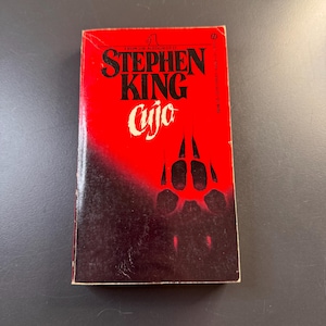 May include: A set of three ceramic mugs with a speckled, cream-colored glaze. Each mug features a different hand-painted design: a sun, a moon, and a star. The mugs have a simple, modern design with a rounded shape.