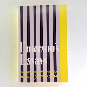 Puede incluir: Un libro titulado "Emerson's Essays" con una cubierta a rayas blancas y negras y un lomo amarillo. El t&iacute;tulo del libro est&aacute; en texto blanco y el subt&iacute;tulo es "First & Second Series Complete in One Volume" con una introducci&oacute;n de "IRWIN EDMAN".