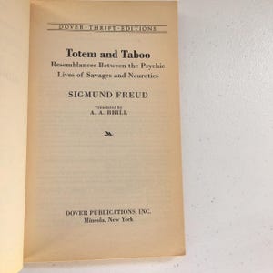 May include: A book cover with the title "Totem and Taboo" by Sigmund Freud. The book is a Dover Thrift Edition and was translated by A. A. Brill.