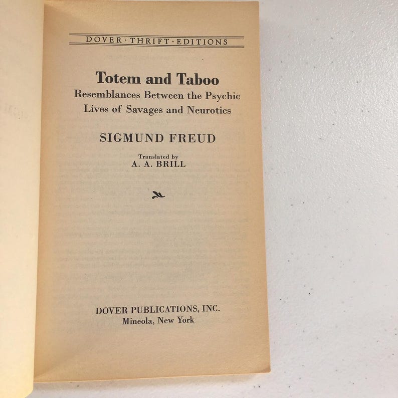 May include: A book cover with the title "Totem and Taboo" by Sigmund Freud. The book is a Dover Thrift Edition and was translated by A. A. Brill.