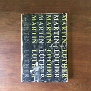 May include: A black and yellow book titled "Martin Luther" by John M. Todd.