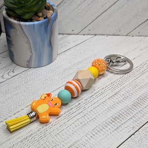 Llavero de bolsillo de dragón de fuego naranja con dije de silicona de 18 cm y borla