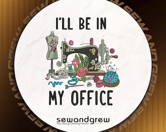 Puede incluir: Un parche circular blanco con el texto negro I'LL BE IN MY OFFICE. El diseño incluye una máquina de coser negra bordada, un maniquí con detalles florales, tijeras, carretes de hilo y un alfiletero azul con alfileres de colores.