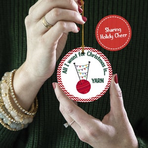 A crocheter is holding a personalized knitting Christmas ornament.