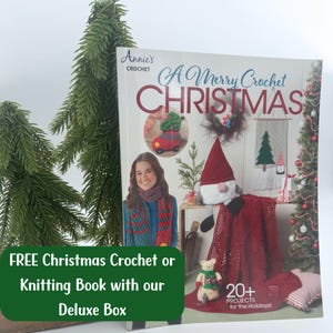 May include: A book titled "A Merry Crochet Christmas" by Annie's Crochet featuring a red crocheted blanket, a gnome, and a woman wearing a crocheted scarf. The book cover has a red and white striped background with the text "20+ Projects for the Holidays!"