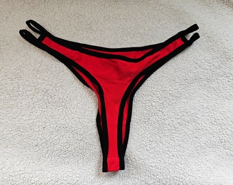 Red cut-out thong with black contrast binding