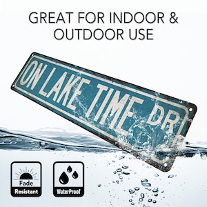 May include: A blue and white metal sign with the text "ON LAKE TIME DR" in white lettering. The sign is partially submerged in water and has a distressed, rusty look. The sign is fade resistant and waterproof.