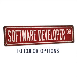 Puede incluir: Señal de metal roja con texto blanco que dice "SOFTWARE DEVELOPER DR". La señal tiene un aspecto desgastado y vintage.  10 OPCIONES DE COLOR se imprimen debajo de la señal.