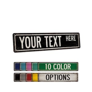 May include: A rectangular metal sign with a distressed black finish and white border, featuring the text YOUR TEXT HERE. Below, two rows display ten smaller rectangular signs in various solid colors, labeled 10 COLOR OPTIONS.