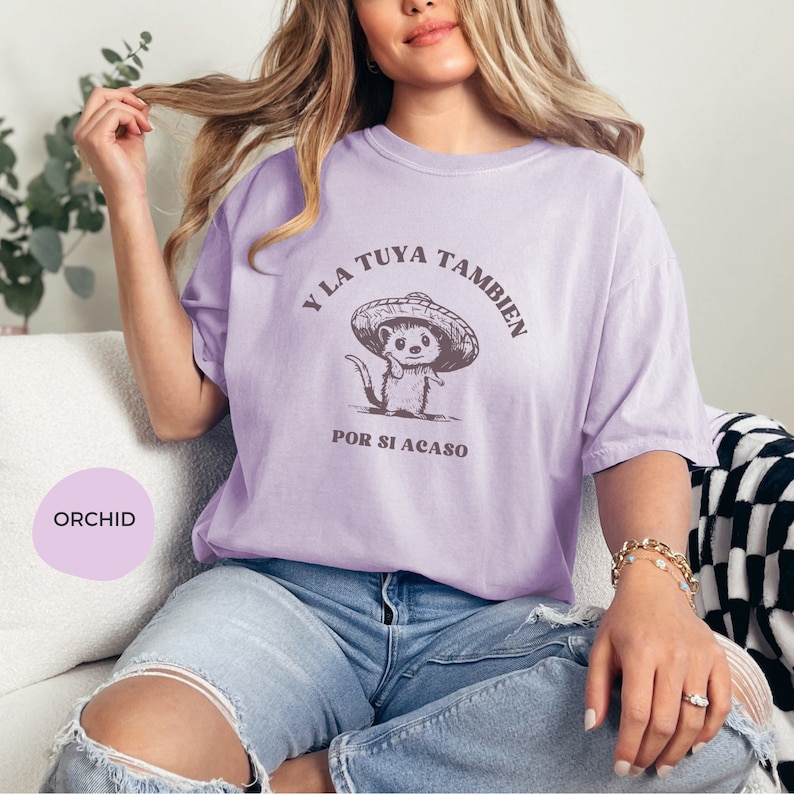 Pode incluir: Uma camiseta lavanda com um gr&aacute;fico de um rato de desenho animado usando um sombrero. O texto na camiseta diz "Y la tuya tambien por si acaso".