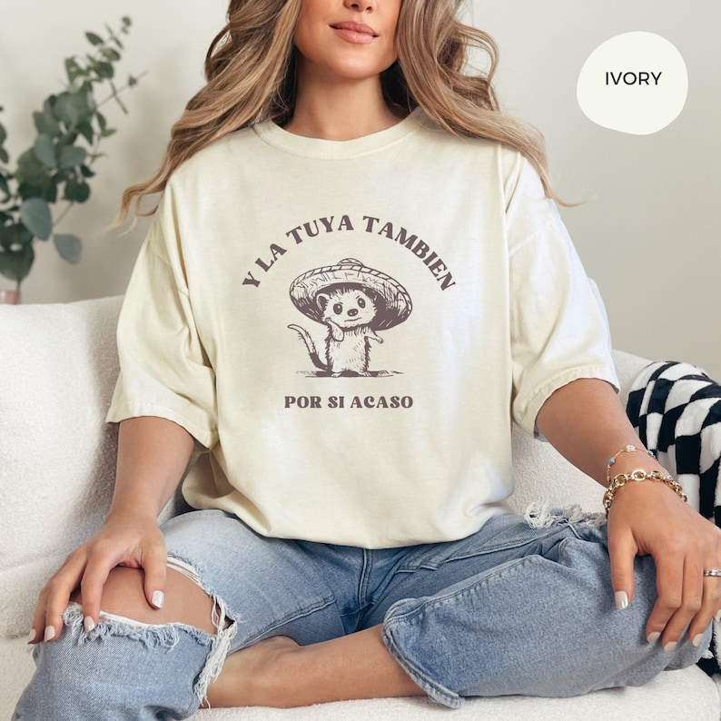 Pode incluir: Uma camiseta bege claro com um gr&aacute;fico de um rato de desenho animado usando um sombrero. O texto na camiseta diz "Y LA TUYA TAMBIEN POR SI ACASO".