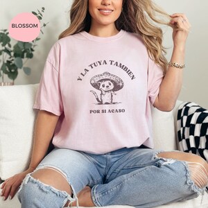 Pode incluir: Uma camiseta rosa com um gr&aacute;fico de um animal de desenho animado usando um sombrero. O texto na camiseta diz "Y LA TUYA TAMBIEN POR SI ACASO".