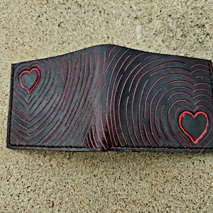 Dos corazones, arte abstracto. Cartera de piel negra y roja.