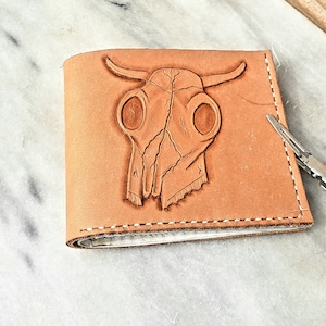 Cartera plegable de piel con calavera de vaca occidental. Tallado y repujado a mano.