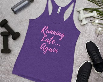 Puede incluir: Una camiseta sin mangas morada con el texto rosa "Running Late... Again". La imagen incluye zapatillas negras, pesas, una botella de agua y gafas, lo que sugiere un tema de fitness o estilo de vida activo.