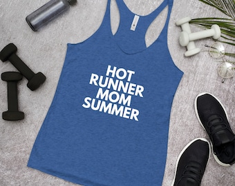 Puede incluir: Camiseta sin mangas azul con el texto blanco "HOT RUNNER MOM SUMMER". La imagen incluye pesas negras, una botella de agua, pesas blancas, zapatillas negras y gafas.