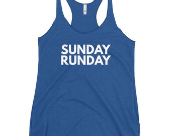 Puede incluir: Una camiseta sin mangas azul con el texto blanco "SUNDAY RUNDAY" impreso en la parte delantera. La camiseta sin mangas tiene un diseño de espalda nadadora con tirantes finos y un escote redondo. La tela parece ser un material suave y ligero.