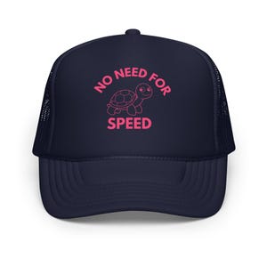 May include: A navy blue trucker hat with a pink outline of a turtle and the text "NO NEED FOR SPEED".