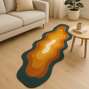 May include: A colorful, wavy rug with a layered design in shades of teal, orange, yellow, and white. The rug is placed on a light wood floor, adding a pop of color to the room. The rug's dimensions are approximately 60 inches long.
