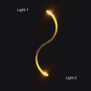 May include: A curved, yellow light fixture with illuminated ends, labelled "Light 1" and "Light 2". The fixture has a wavy design against a dark background.