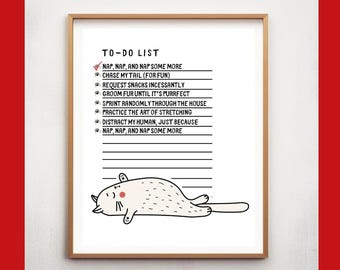 May include: A framed print with a white background and a cat-themed to-do list. The list includes activities like napping, chasing tails, and requesting snacks. A cartoon cat illustration is at the bottom of the print.