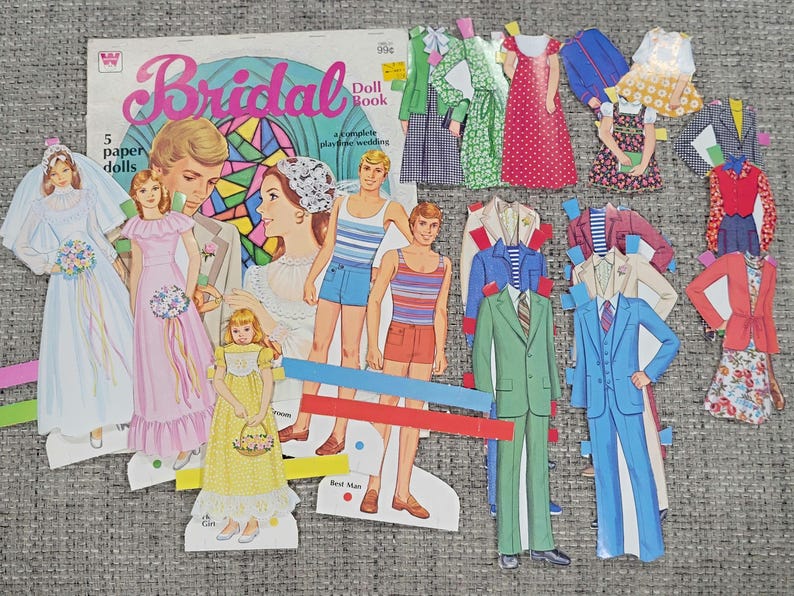 K&ouml;nnte beinhalten: Ein Vintage "Bridal Doll Book" mit Papierpuppen und Outfits. Das Cover zeigt Illustrationen eines Brautpaares. Das Set enth&auml;lt Papierpuppen einer Braut, Brautjungfern und Br&auml;utigame sowie verschiedene Outfits f&uuml;r ein Hochzeitsthema.