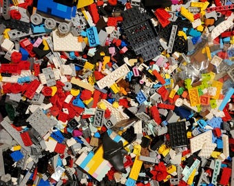 May include: A vibrant assortment of colorful plastic building blocks, including red, blue, yellow, and gray pieces. A small blue train is visible among the blocks. The image showcases a variety of shapes and sizes, suggesting a creative play environment.