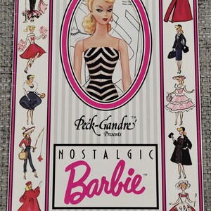 K&ouml;nnte beinhalten: Ein Vintage-Barbie-Papierpuppen-Set. Das Cover zeigt eine Barbie-Illustration in einem schwarz-wei&szlig; gestreiften Kleid, umrahmt in Pink. Der Text lautet "Nostalgic Barbie Paperdoll" mit dem Peck-Gandre-Logo.