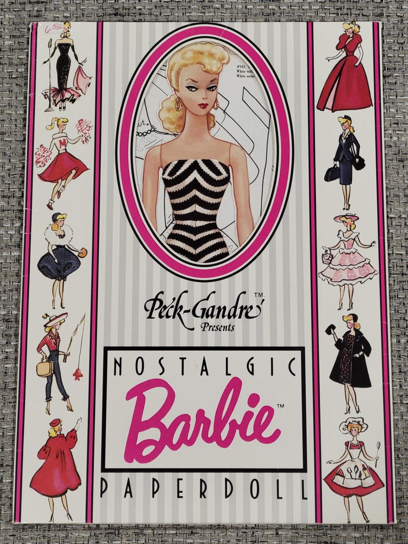 K&ouml;nnte beinhalten: Ein Vintage-Barbie-Papierpuppen-Set. Das Cover zeigt eine Barbie-Illustration in einem schwarz-wei&szlig; gestreiften Kleid, umrahmt in Pink. Der Text lautet "Nostalgic Barbie Paperdoll" mit dem Peck-Gandre-Logo.