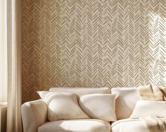 May include: A white sofa with beige throw pillows and a beige throw blanket sits in front of a wall with a beige chevron pattern wallpaper.