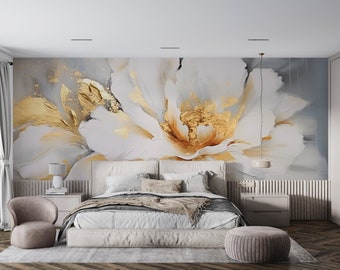 May include: A bedroom interior with a white and gold floral wall mural, a white bed with a gray blanket, a gray chair, and a gray ottoman.