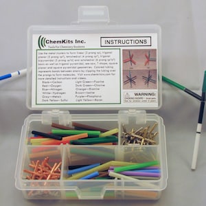 May include: A ChemKits Inc. chemistry set for students, featuring a clear plastic container with various colored rods and connectors. The set includes instructions and example molecular models. Three assembled models are displayed.