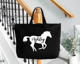 May include: Black tote bag with a white silhouette of a horse and the name "Ashley" written underneath.