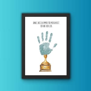 Könnte beinhalten: Gerahmter Druck mit einem Handabdruck-Design auf einer goldenen Trophäenbasis. Der Handabdruck ist strukturiert und hellblau. Der Druck enthält deutschen Text: "DANKE, DASS DU IMMER FÜR MICH DA BIST. ICH HAB DICH LIEB."