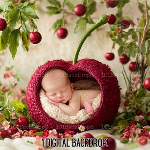 May include: A newborn baby sleeping in a red cherry-shaped basket with a green stem. The basket is surrounded by green leaves and red cherries.