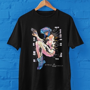 May include: Black t-shirt with a graphic print of a female anime character with blue hair and a gun. The text "GHOST IN THE SHELL" is printed below the character.