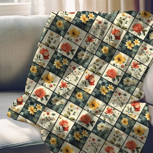 May include: A floral patterned throw blanket featuring a patchwork design with squares of flowers in yellow, orange, and white. The blanket is draped over a gray sofa, showcasing its decorative appeal.
