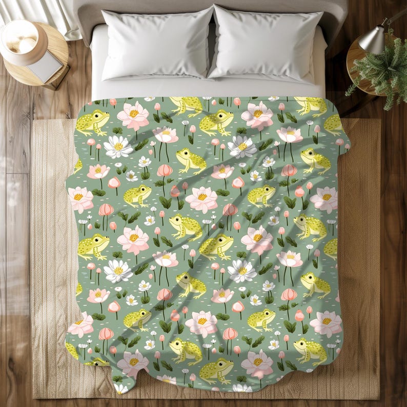 May include: A green and white patterned bedspread with a repeating pattern of frogs, flowers, and leaves.