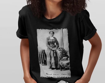 May include: Black t-shirt with a vintage photo of a woman standing in front of a chair. The photo is in black and white and has a distressed look. The text below the photo reads "Mary Johnson (circa 1855) Born a slave, and now free."