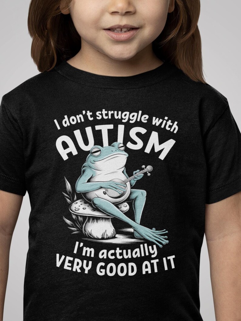 May include: Black t-shirt with a white frog playing a banjo on a mushroom. The text on the shirt reads "I don't struggle with AUTISM I'm actually VERY GOOD AT IT."