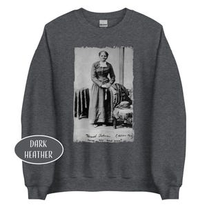 May include: Dark heather gray sweatshirt featuring a black and white image of Harriet Tubman. The image includes text that reads "Harriet Tubman (1823-1913) nurse, spy and scout."
