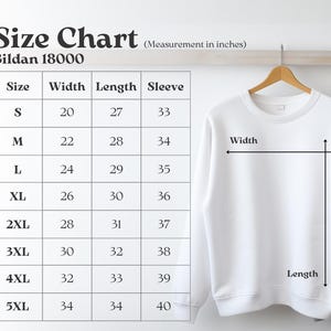 May include: A white Gildan 18000 sweatshirt hangs on a wooden hanger next to a size chart. The chart displays measurements in inches for width, length, and sleeve length, ranging from size S to 5XL. The chart is labeled "Size Chart".