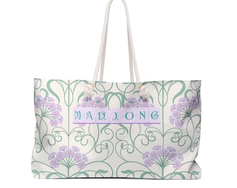 May include: A white canvas tote bag with a floral pattern and the word "MAHJONG" spelled out in green letters on a purple background.