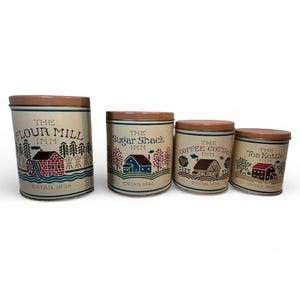Puede incluir: Juego de cuatro botes de cocina vintage con tapas marrones y cuerpos color crema. Cada bote presenta una ilustración y un texto diferentes: "The Flour Mill Inn", "The Sugar Shack Inn", "The Coffee Cottage Inn" y "The Tea Kettle Inn".